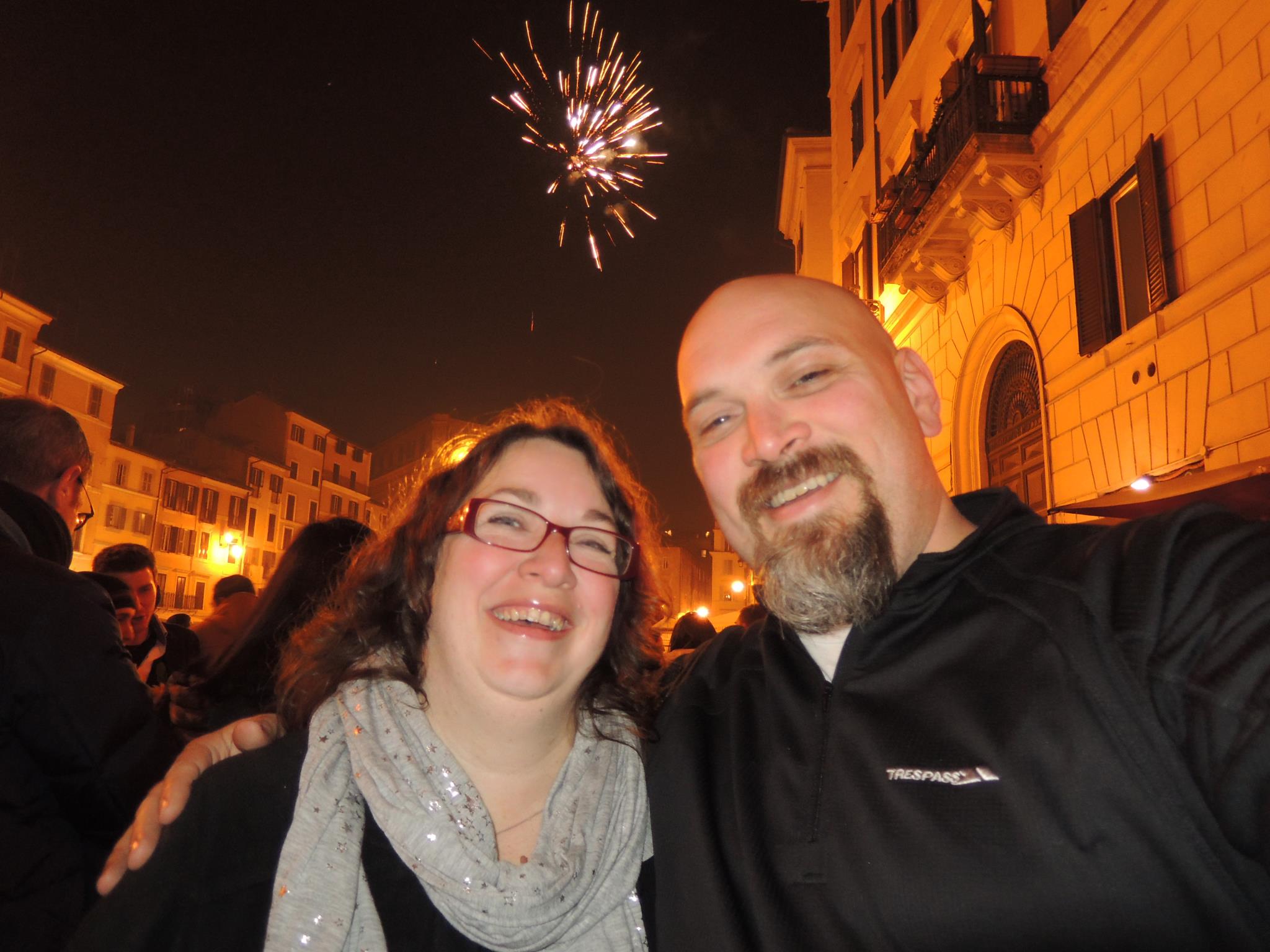 Two people in front of fireworks in the background.